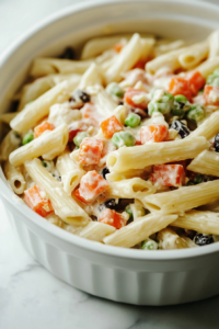 Close-up shot of the finished dish served in a bowl, garnished with fresh parsley and a sprinkle of red pepper flakes. The creamy pasta dish sits on a plate with a soft shine, ready to be enjoyed