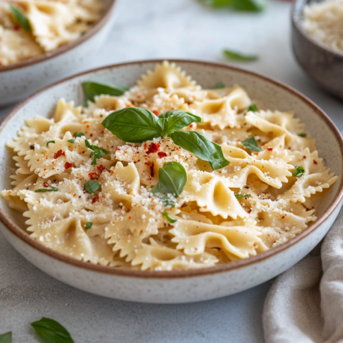 Wide shot of a table set with bowls of creamy coconut milk pasta, topped with fresh basil, red pepper flakes, and extra vegan parmesan. The dish is warm and inviting, ready to be enjoyed.