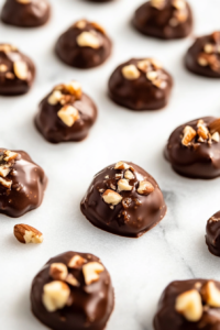 Close-up shot of the finished chocolate-nut clusters, firming up on parchment paper after about an hour. The candies are now set and ready to be transferred to an air-tight container, with the white marble cooktop in the background.