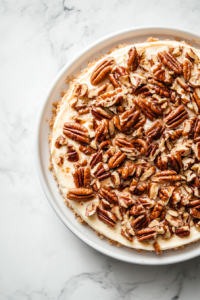 The finished carrot cake cheesecake, topped with caramelized pecans and ready to be served."