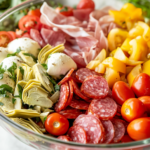 A close-up of a wooden spoon gently tossing the vibrant antipasto salad in a glass bowl over a white marble cooktop, blending all the flavors together for a delicious, well-balanced dish.