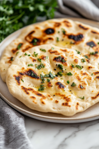 A warm, golden flatbread resting on a plate over the white marble cooktop, lightly sprinkled with oregano, ready to be enjoyed as a savory and satisfying dish.