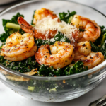 The fully assembled Kale Cajun Shrimp Salad in a glass salad bowl on a white marble cooktop. Freshly grated Parmesan cheese is sprinkled on top, completing the dish, with a fork resting nearby, ready to dig in.