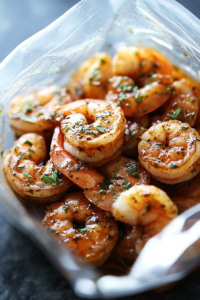 Shrimp in a sealed bag with half of the marinade, being refrigerated for 15 minutes to soak up the flavors.