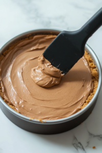 A saucepan on a stovetop with Biscoff spread gently melting, forming a smooth, glossy consistency.
