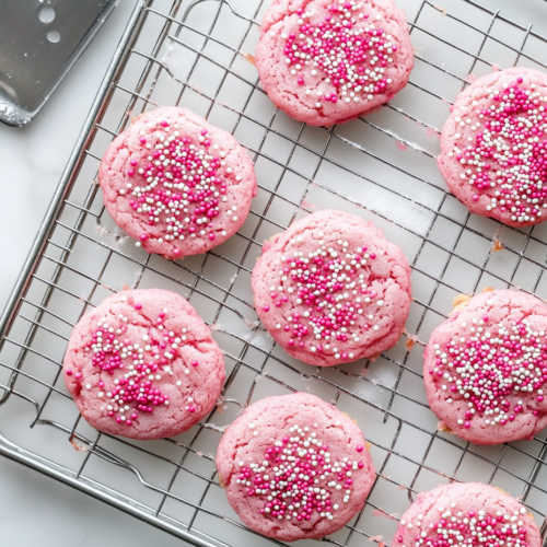 A tray of freshly baked pink cookies cooling on a wire rack, ready to be enjoyed after reaching the perfect texture.