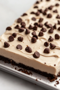 Close-up shot of smooth chocolate ganache being poured over the chilled cheesecake, creating a glossy, rich topping. The cheesecake is ready for a final chill before serving