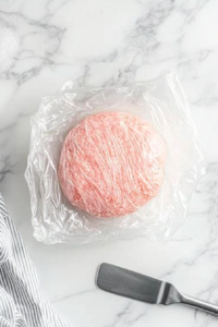 The pink cookie dough covered with plastic wrap and placed in the fridge to chill for one hour before baking