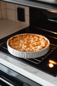Close-up shot of the crust baking in the oven, with golden edges visible through the oven window, and the timer showing 10 minutes.