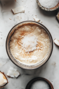 Close-up shot of a blender on the white marble cooktop with silken tofu, full-fat coconut milk, granulated sugar, cornstarch, vanilla extract, salt, nutmeg, and turmeric being blended into a smooth custard. The mixture swirls as it blends