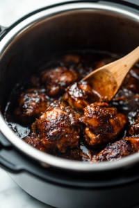 The Instant Pot lid is being lifted on a white marble cooktop, revealing tender, juicy jerk chicken simmering in a thickened sauce. A wooden spoon stirs the glossy, spicy marinade around the cooked chicken.