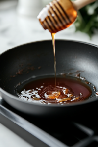 A black skillet on a white marble cooktop shows a steady stream of heavy cream being poured into the tomato-based sauce. The mixture turns smooth and velvety, developing a rich orange hue as it simmers.