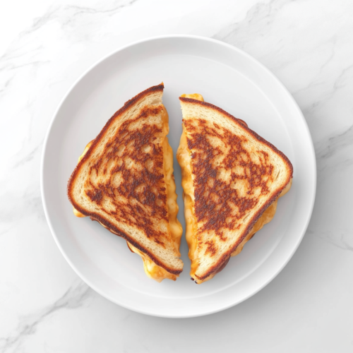 A close-up top-down view of two grilled cheese sandwiches made with thick Texas toast, stacked on a white ceramic plate. The bread is golden brown and crispy, and the melted cheddar, gouda, and havarti cheese ooze out from the middle. The sandwiches are placed on a clean white marble countertop with a simple and minimal background, perfect for showcasing the delicious texture and cheesy interior.